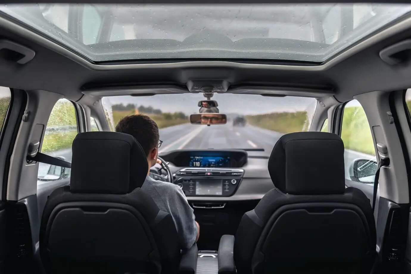 Водитель за рулём в дождливый осенний день во время автопутешествия.